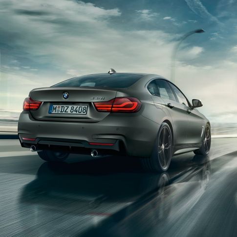 BMW 4 серии Gran Coupé, вид сзади с поворотом в три четверти в движении BMW 4 серии Gran Coupé, вид сзади с поворотом в три четверти в движении