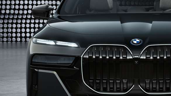 Эффектный дизайн передней части, BMW M760e xDrive G70 Капот и решетка радиатора с логотипом "M", BMW M760e xDrive G70, BMW Individual двухцветная окраска "Черный Сапфир металлик" и "BMW Individual Серый Дравит металлик", крупный план