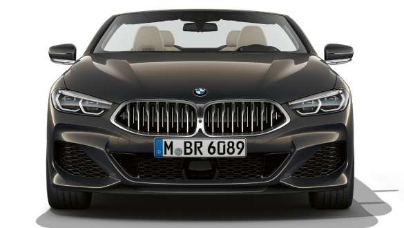 BMW M850i xDrive Кабриолет, передняя часть. BMW M850i xDrive Кабриолет в Dravit Grey металлик с открытой мягкой крышей, спереди с двойной решеткой в Galvanic Cerium Grey.