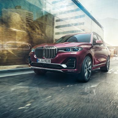 BMW Individual X7 40i xDrive, вид спереду три чверті BMW X7 кольору Ametrin металік в русі, вид спереду три чверті