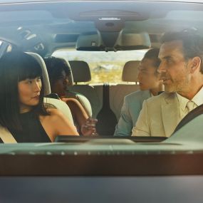 Управление жестами BMW Мужчина и женщина сидят в машине, женщина использует управление жестами