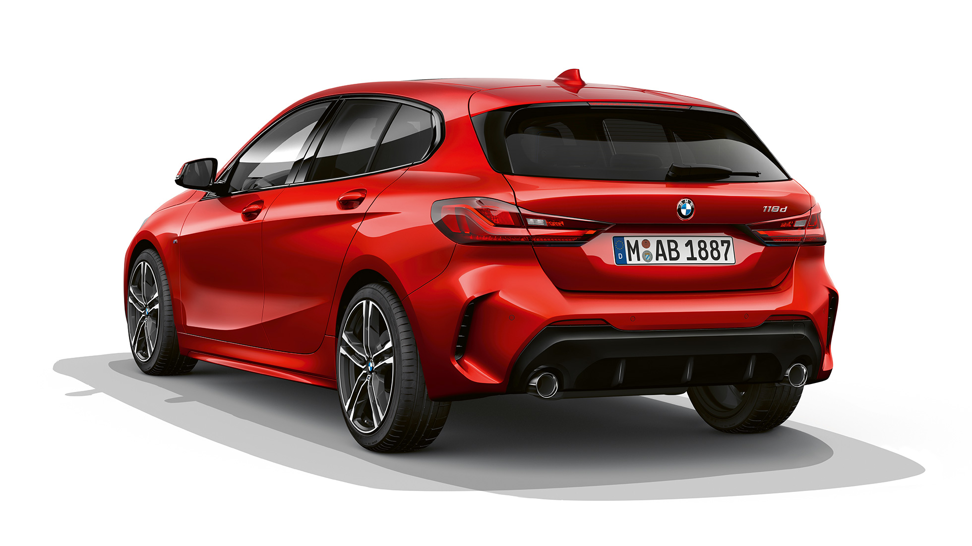 BMW 1 серии модель M Sport, вид сзади с поворотом в три четверти. BMW 1 серии модель M Sport в Melbourne Red металлик, студийный снимок сзади с поворотом в три четверти.