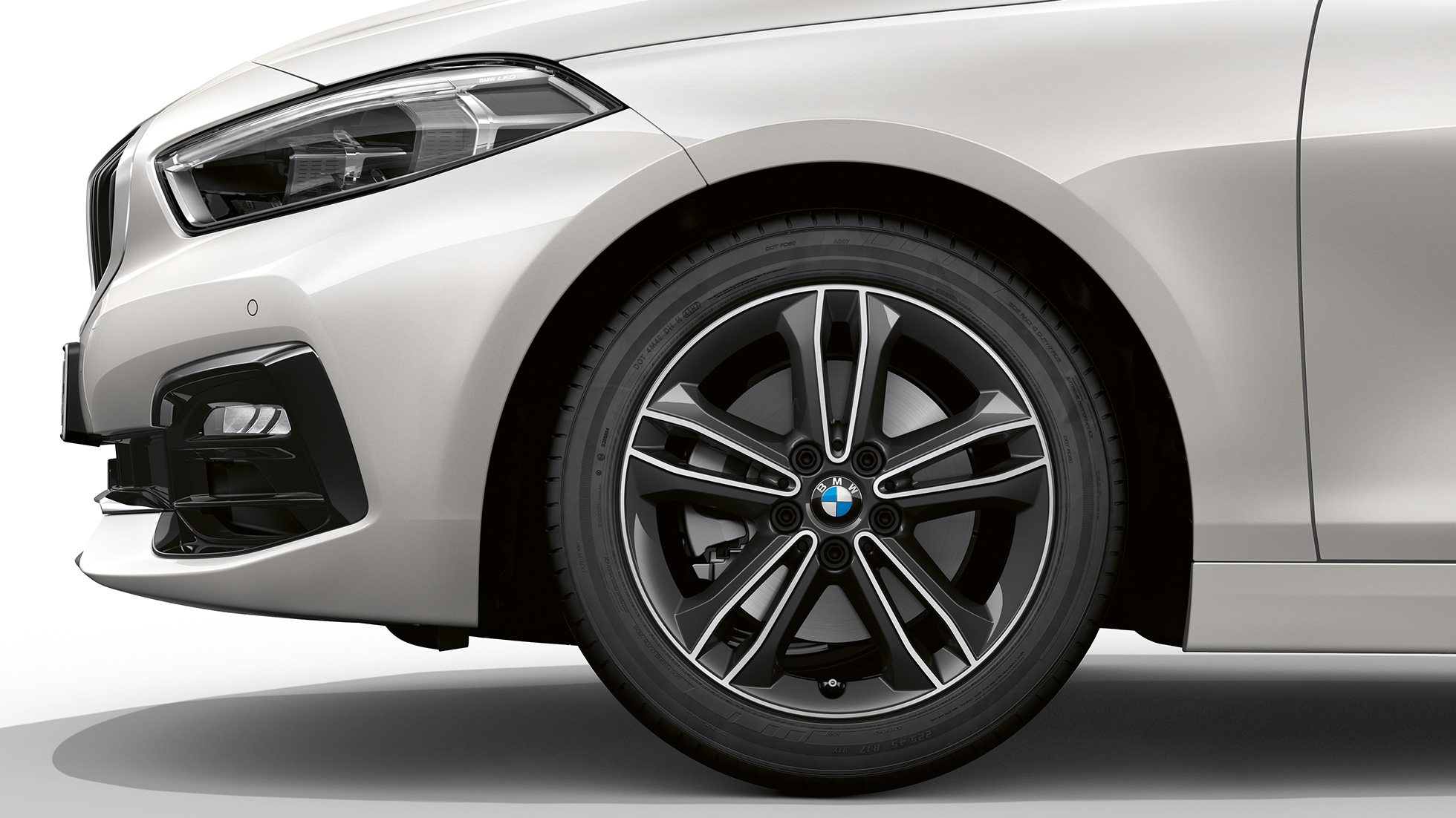 17-дюймовые легкосплавные диски с двойными спицами, стиль 549. BMW 1 серии модель Sport Line в Mineral White металлик, спереди сбоку с 17-дюймовыми легкосплавными дисками с двойными спицами, стиль 549.