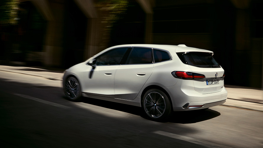 BMW 2 серии Active Tourer U06 2021, вид сбоку BMW 2 серии Active Tourer U06 2021 в цвете Mineral White металлик в движении на улице, вид сбоку