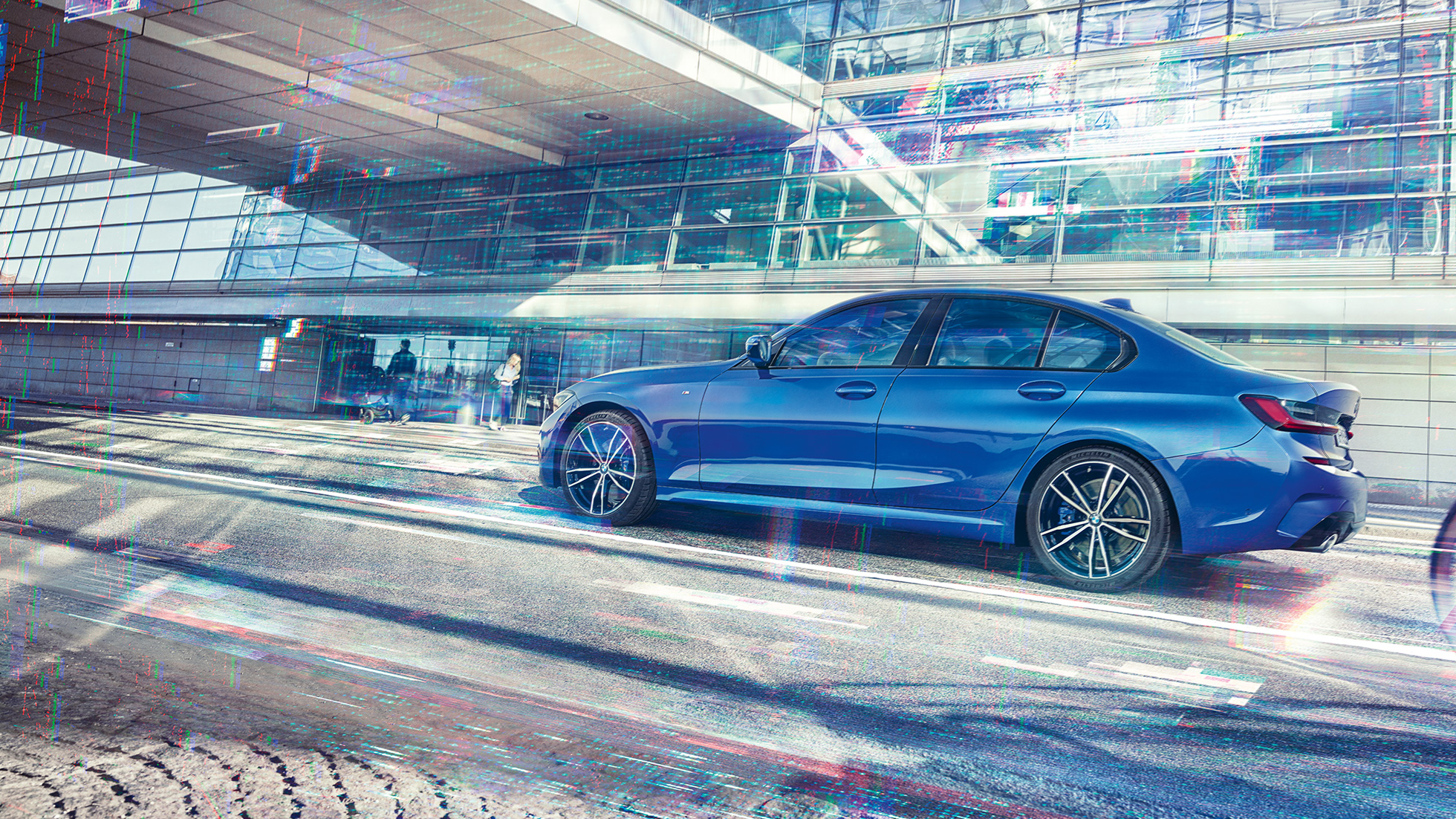 BMW 3 серии Седан, вид сбоку. Боковой снимок седана BMW 3 серии в день перед стеклянным зданием.