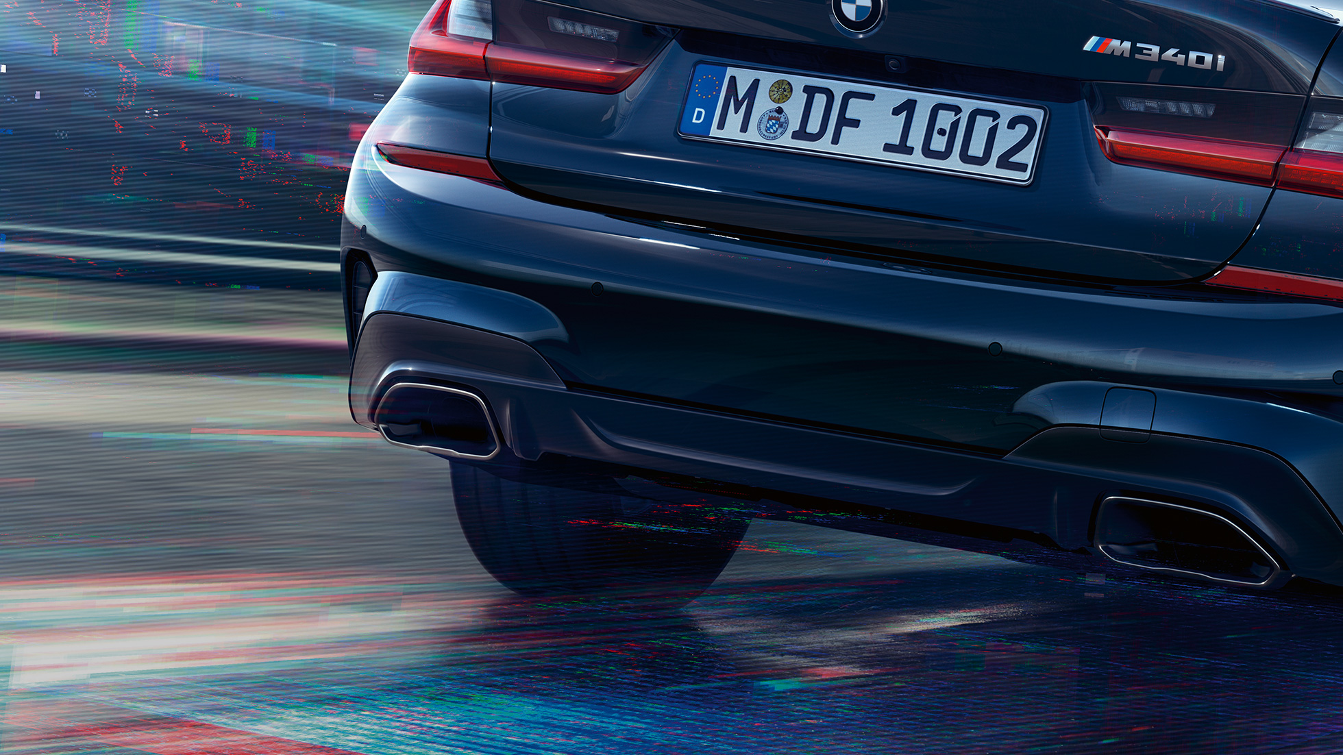 BMW 3 серии Седан, выхлопные трубы М. Крупный план задней части седана BMW 3 серии с выхлопными трубами M цвета Cerium grey металлик.