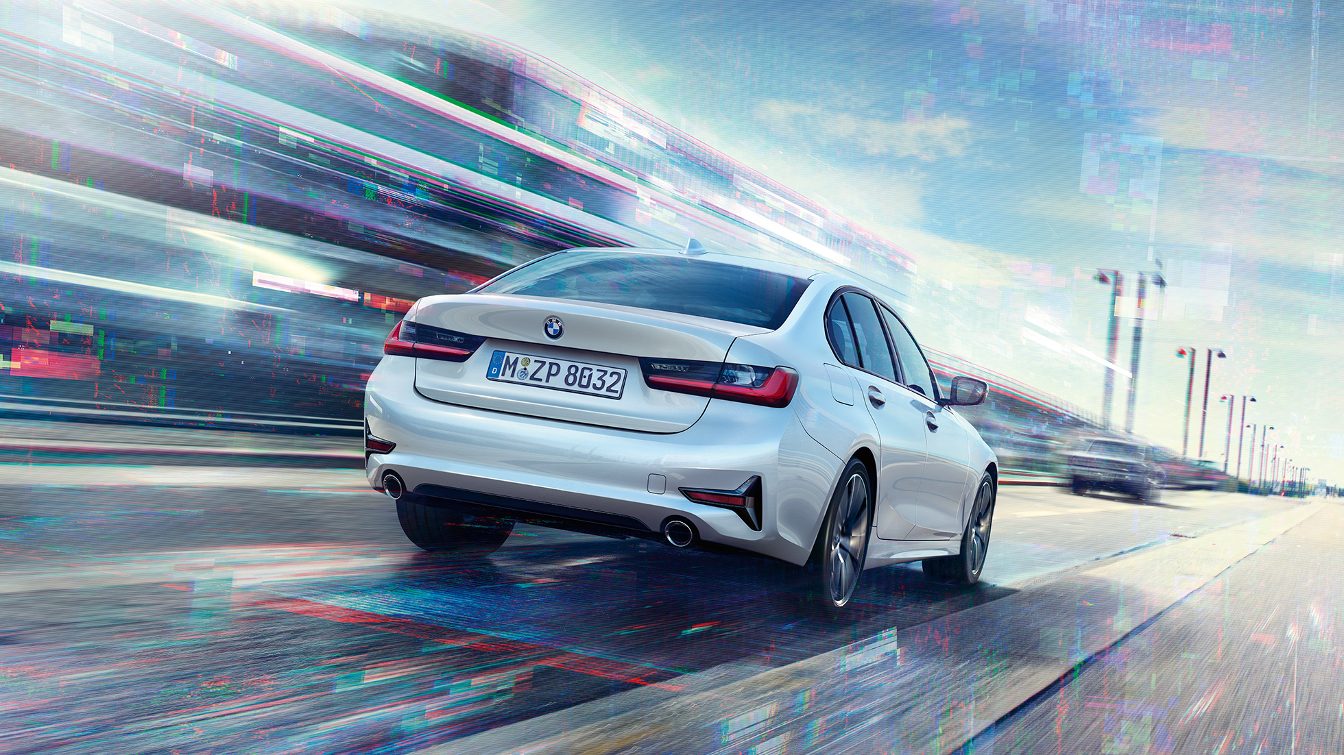 BMW 3 серии Седан 330e, вид сзади. Вид сзади движущегося BMW 3 серии Седан 330е с поворотом в три четверти.