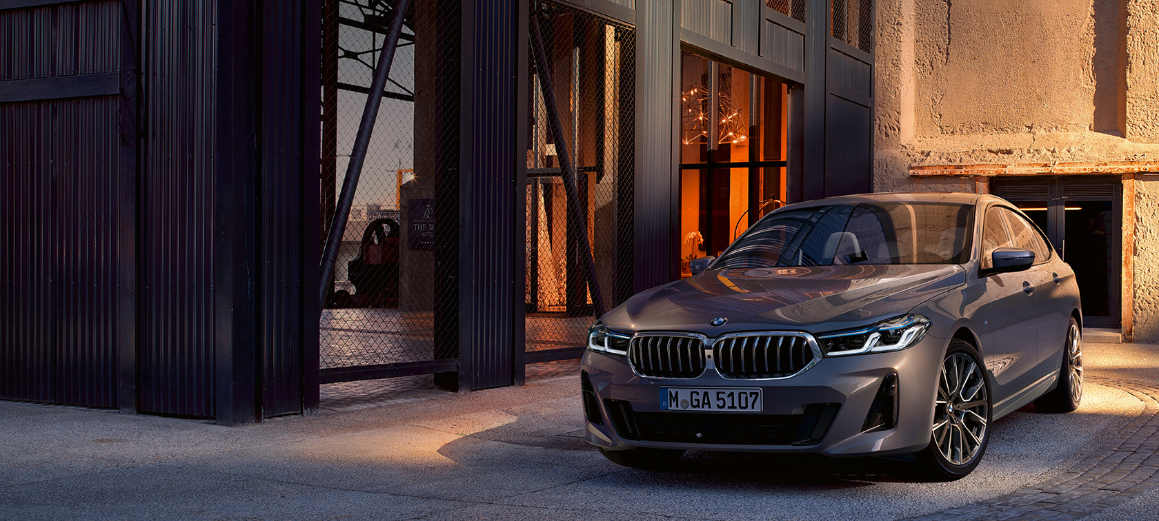 BMW 6 серии GT G32 2020 года BMW 6 серии GT 640i xDrive G32 2020 года, цвет «Серый Бернина», автомобиль находится в зале, вид спереди с поворотом в три четверти
