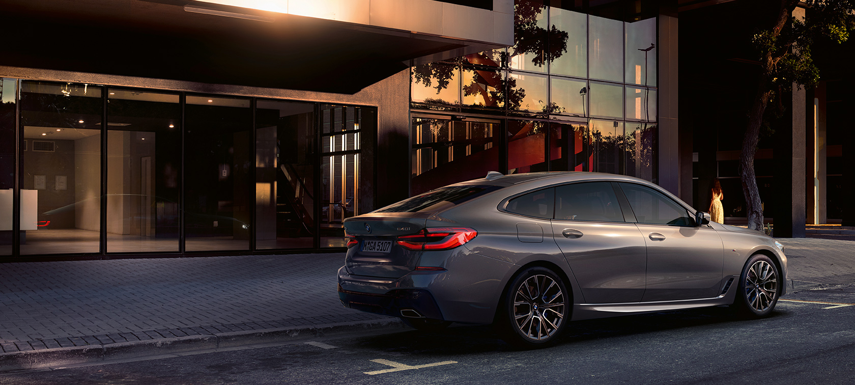 BMW 6 серии GT G32 2020 года BMW 6 серии GT 640i xDrive G32 2020 года, цвет «Серый Бернина», автомобиль припаркован перед зданием, вид сзади и сбоку