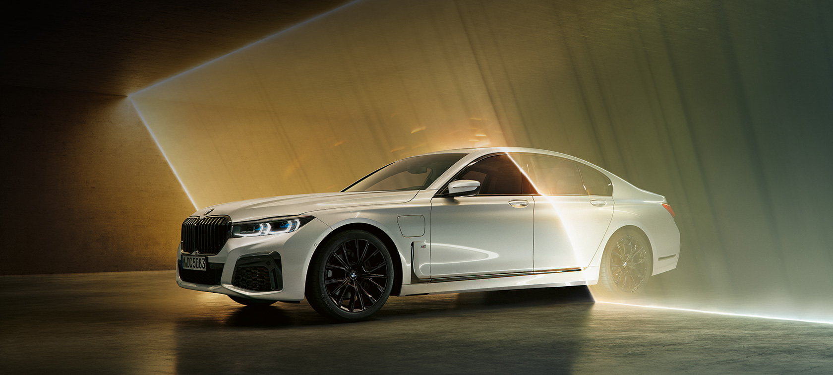 BMW 7 серии Седан белого цвета, вид спереди с поворотом в три четверти BMW 7 серии Седан: белый BMW, вид спереди с поворотом в три четверти в окружении потоков света