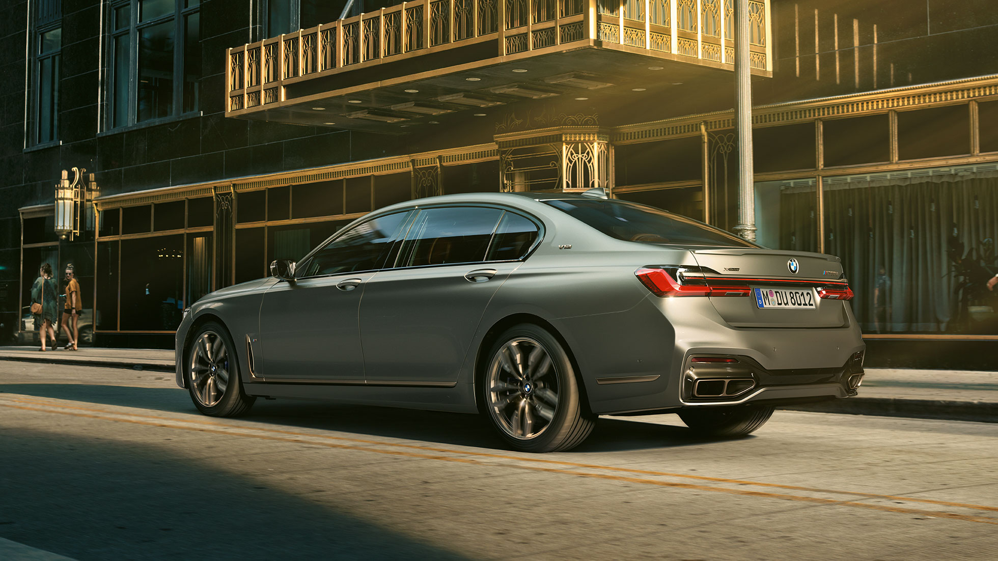 BMW M760Li xDrive с двигателем V12 BMW M760Li xDrive: вид сзади сбоку на фоне городских небоскребов