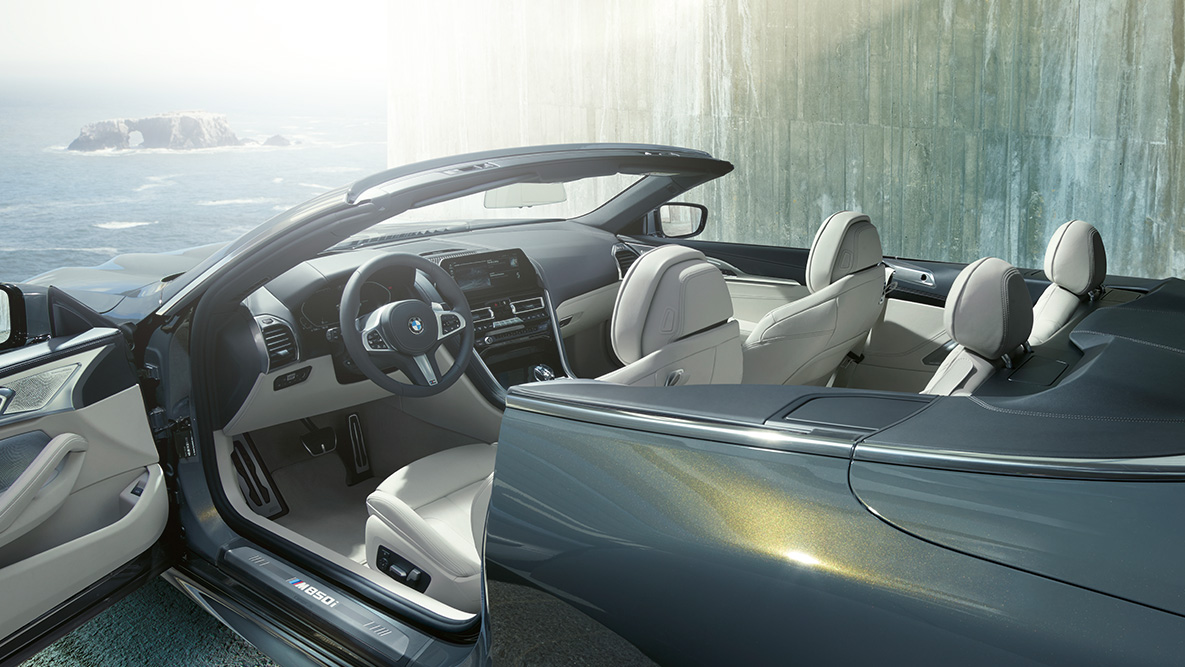 BMW M850i xDrive, Dravit Grey металлик, интерьер, мягкий верх опущен, дверь открыта. BMW M850i xDrive, Dravit Grey металлик, интерьер, мягкий верх опущен, дверь открыта.