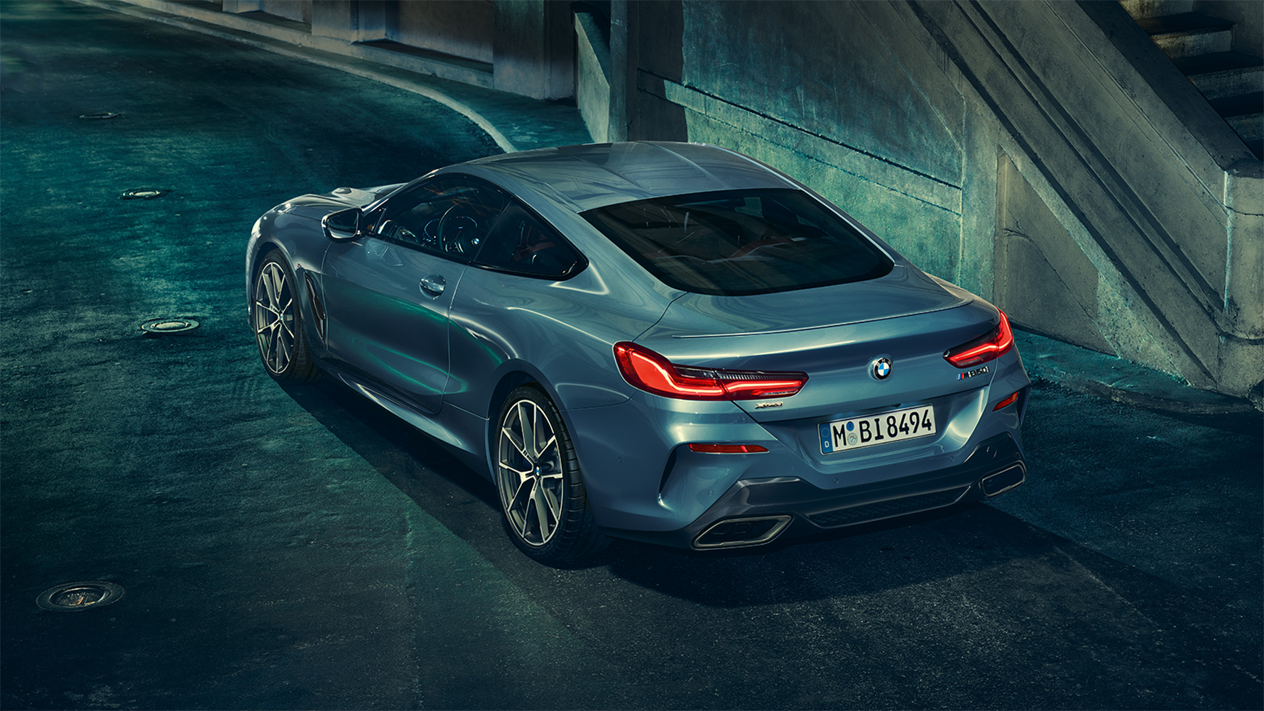 BMW 8 серии Coupe, вид сзади с поворотом в три четверти BMW 8 серии Coupe в ночном городе, вид сзади с поворотом в три четверти.