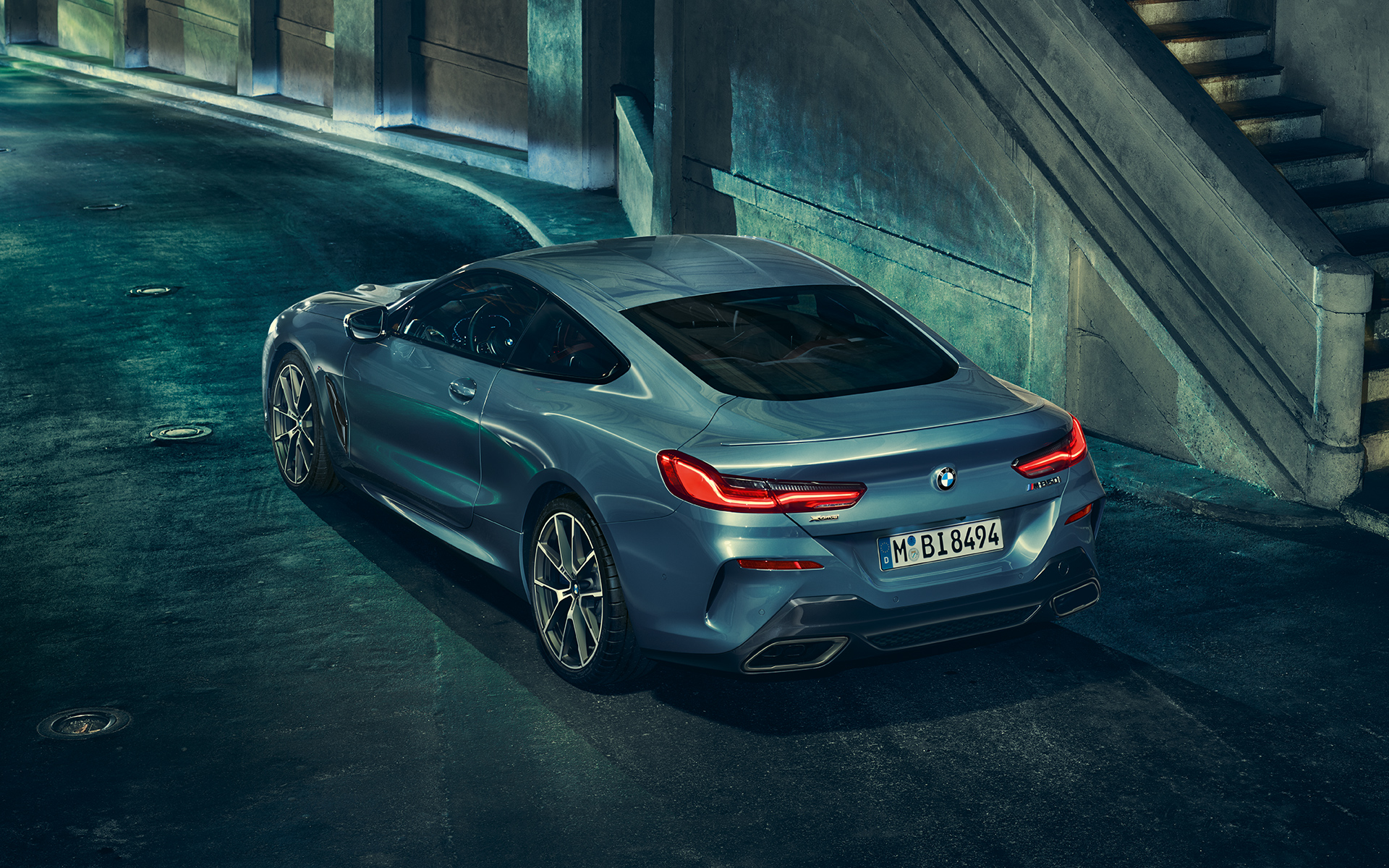 BMW 8 серии Coupe, вид сзади с поворотом в три четверти BMW 8 серии Coupe в городе, вид слева сзади с поворотом в три четверти.