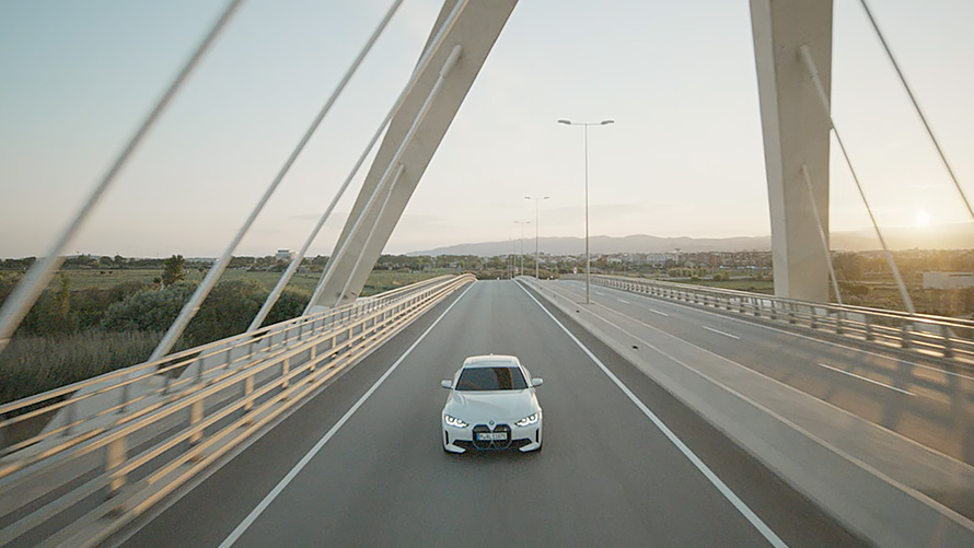 Вид спереди на три четверти на BMW i4 eDrive40 G26 2021 в движении BMW i4 eDrive40 G26 2021 в цвете Mineral White вид спереди в движении