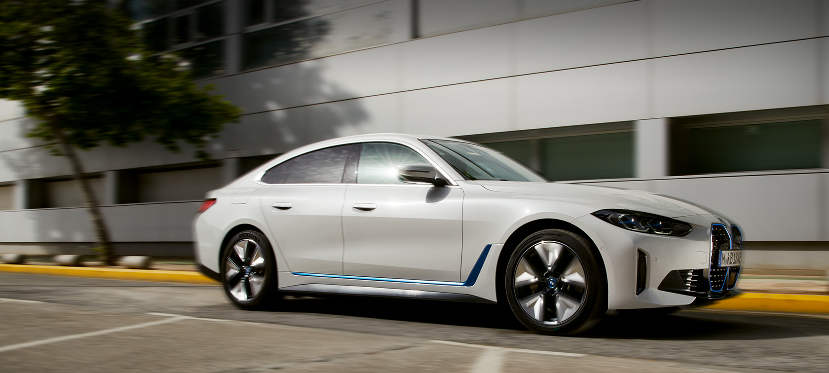 BMW i4 eDrive 40 G26 2021 вид сбоку на три четверти напротив здания BMW i4 eDrive 40 G26 2021 вид сбоку на три четверти напротив здания