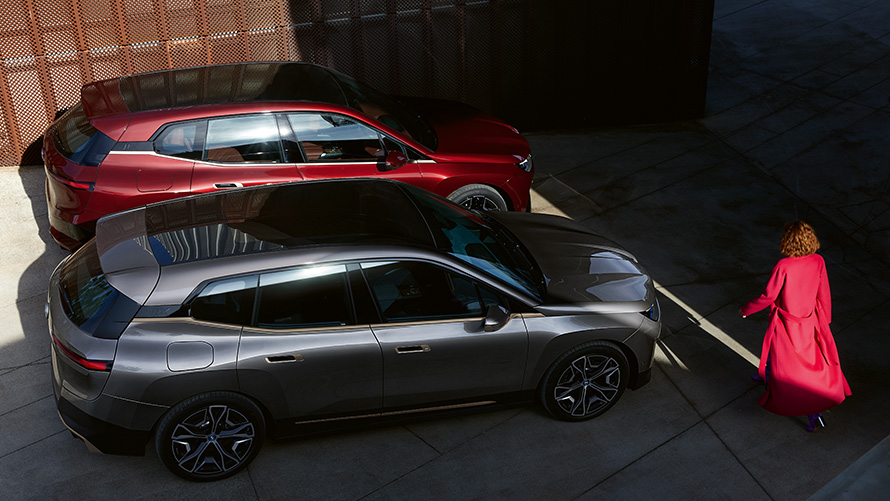 BMW iX M60 в цвете Oxid Grey metallic и BMW iX xDrive50 в цвете Aventurin Red i20 2022 с высоты птичьего полета