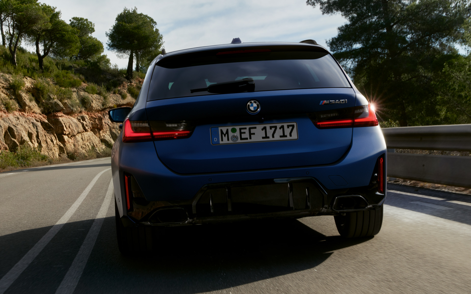 BMW M340i xDrive Touring G21 в цвете Frozen Tanzanite Blue, вид сзади в движении на улице
