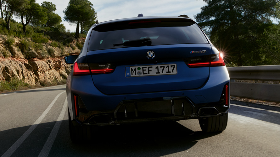 BMW M340i xDrive Touring G21 в цвете Frozen Tanzanite Blue, вид сзади в движении на улице