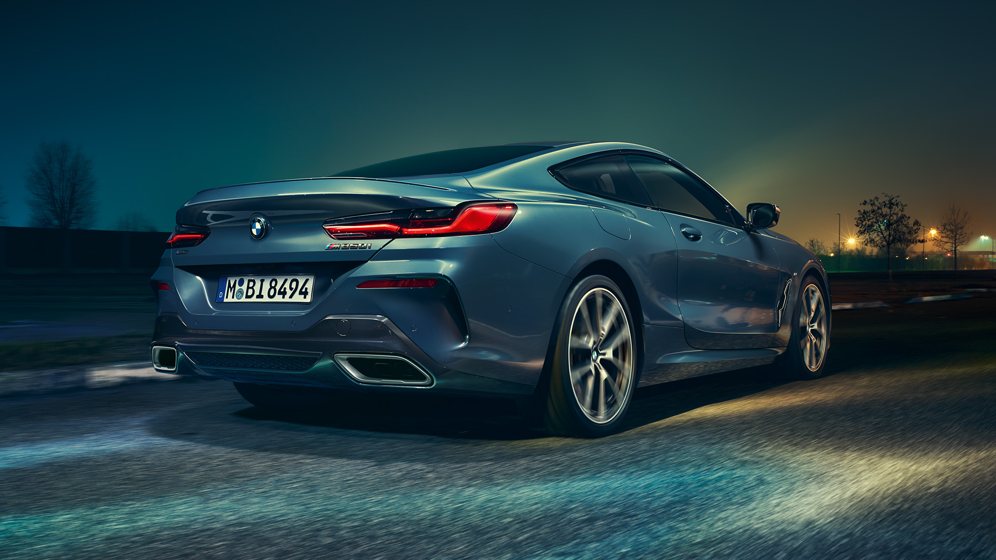 BMW M850i xDrive Coupé, вид сзади. BMW M850i xDrive Coupé в Barcelona Blue металлик, вид сзади, езда ночью.