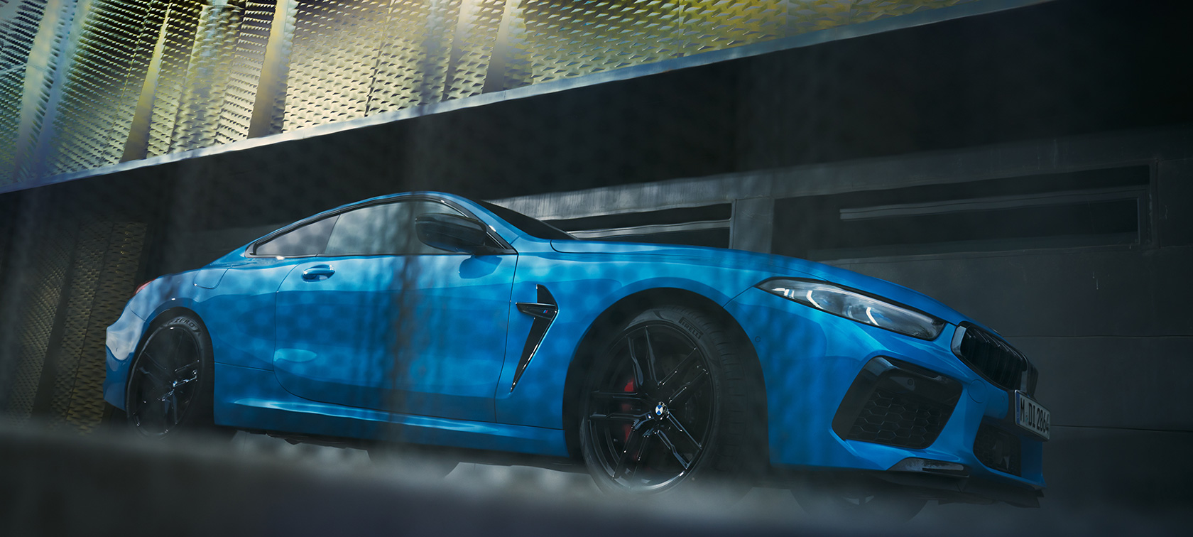 BMW M8 Competition Coupé F92 LCI (рестайлинг 2022 года), вид сбоку перед зданием, снимок снизу BMW M8 Competition Coupé F92 LCI (рестайлинг 2022 года), Синий Дейтона-Бич металлик, вид сбоку перед зданием, снимок снизу