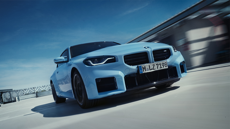 BMW M2 G87, вид спереди в движении по улице BMW M Серии BMW M2 G87, вид спереди в движении по улице