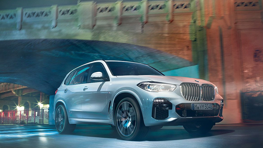 BMW X5 G05 2018 SUV "Белый Минерал металлик", вид спереди в три четверти, в движении ночью