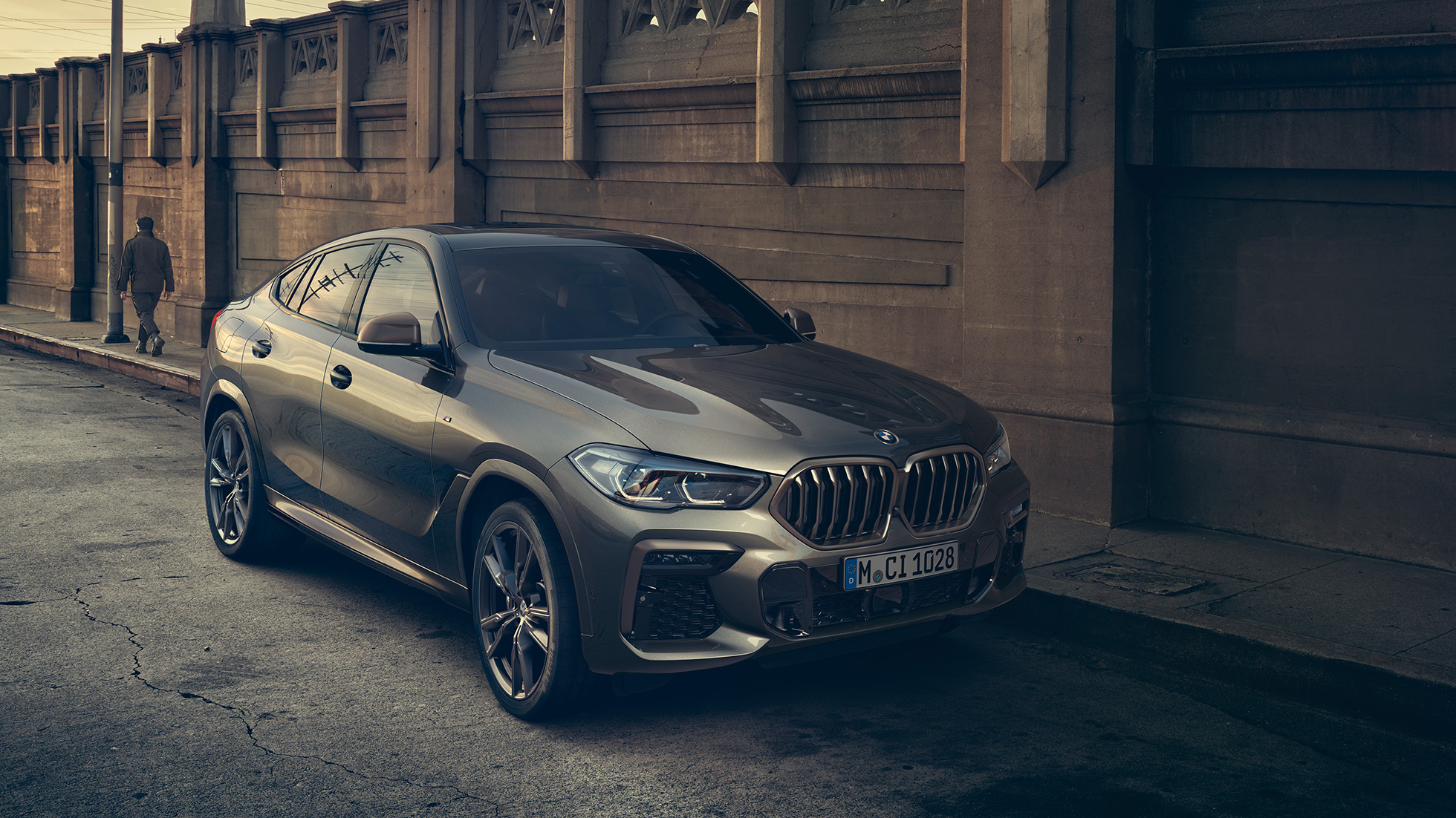 BMW X6 M50i с 8-цилиндровым бензиновым двигателем M TwinPower Turbo BMW X6 M50i G06 с 8-цилиндровым бензиновым двигателем M TwinPower Turbo в цвете Manhattan (металлик), вид сбоку с поворотом в три четверти