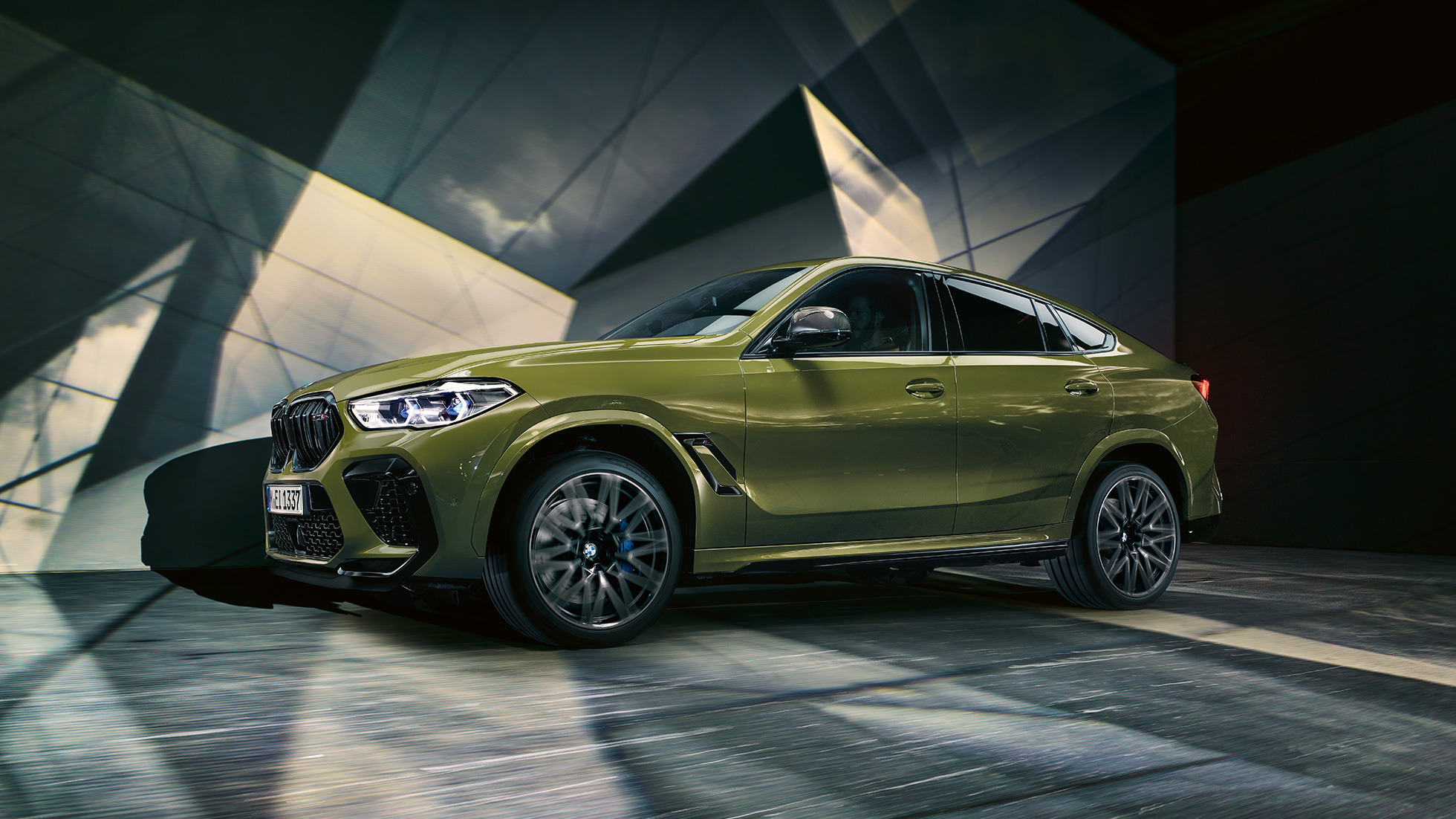 BMW X6 M Competition, вид сбоку BMW X6 M Competition F96 с легкосплавными дисками М, специальное лакокрасочное покрытие зеленого цвета Urban из линейки BMW Individual, вид сбоку