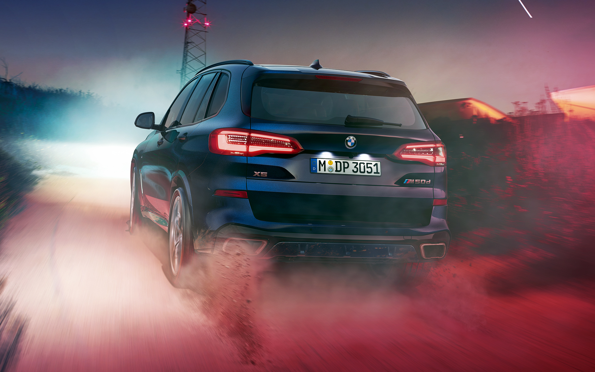 BMW X5 M50d: вид сзади BMW X5 M50d в ночном городе: вид сзади