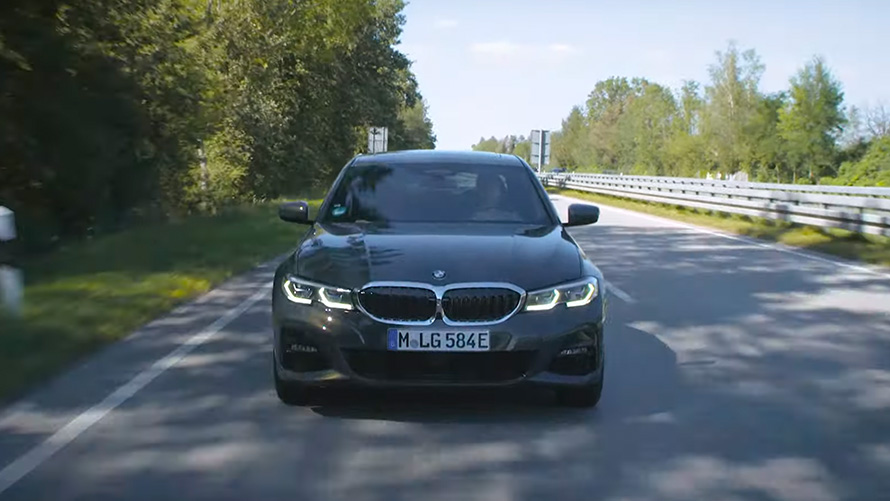 Плагин-гибрид BMW в движении на улице Плагин-гибрид BMW X5 G05, вид спереди при движении на улице