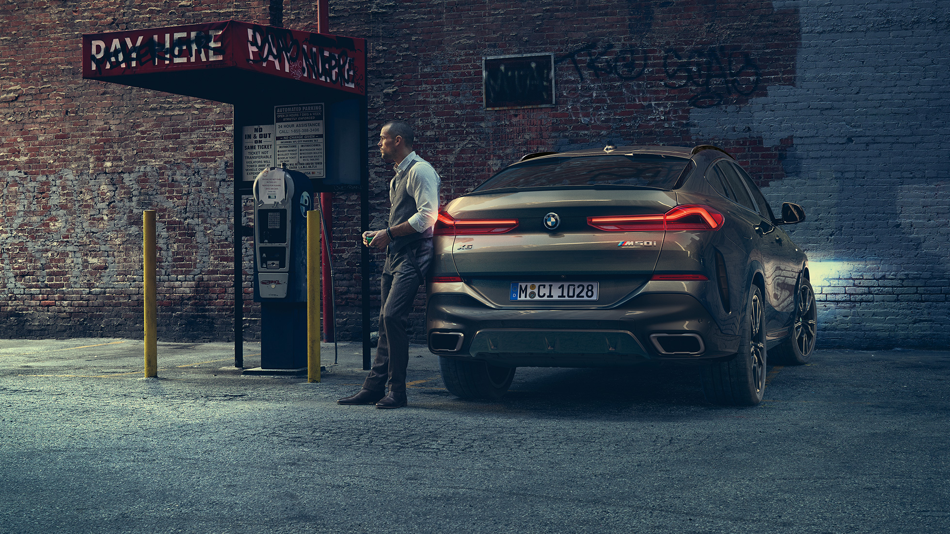 BMW X6, задняя часть. BMW X6 в заднем ракурсе перед городской обстановкой.