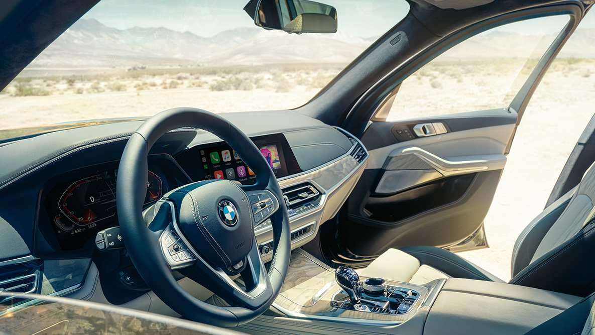 BMW X7 інтер’єр Інтер'єр BMW X7: вид зовні на перший ряд сидінь з видом на рульове колесо, приборну панель та шкіряні сидіння