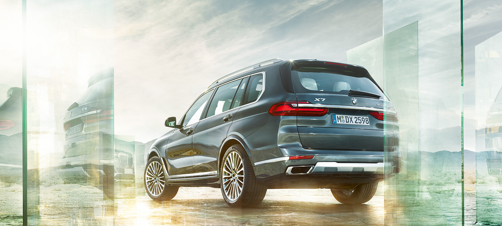 BMW X7 вид сзади в три четверти, в движении BMW X7 G07 2019 "Арктический Серый", вид сзади в три четверти в движении